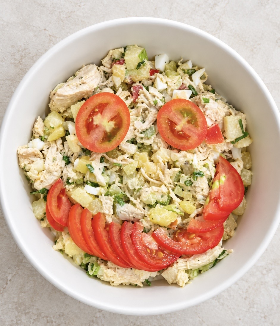 Ensalada de pollo para niños con carita de tomate